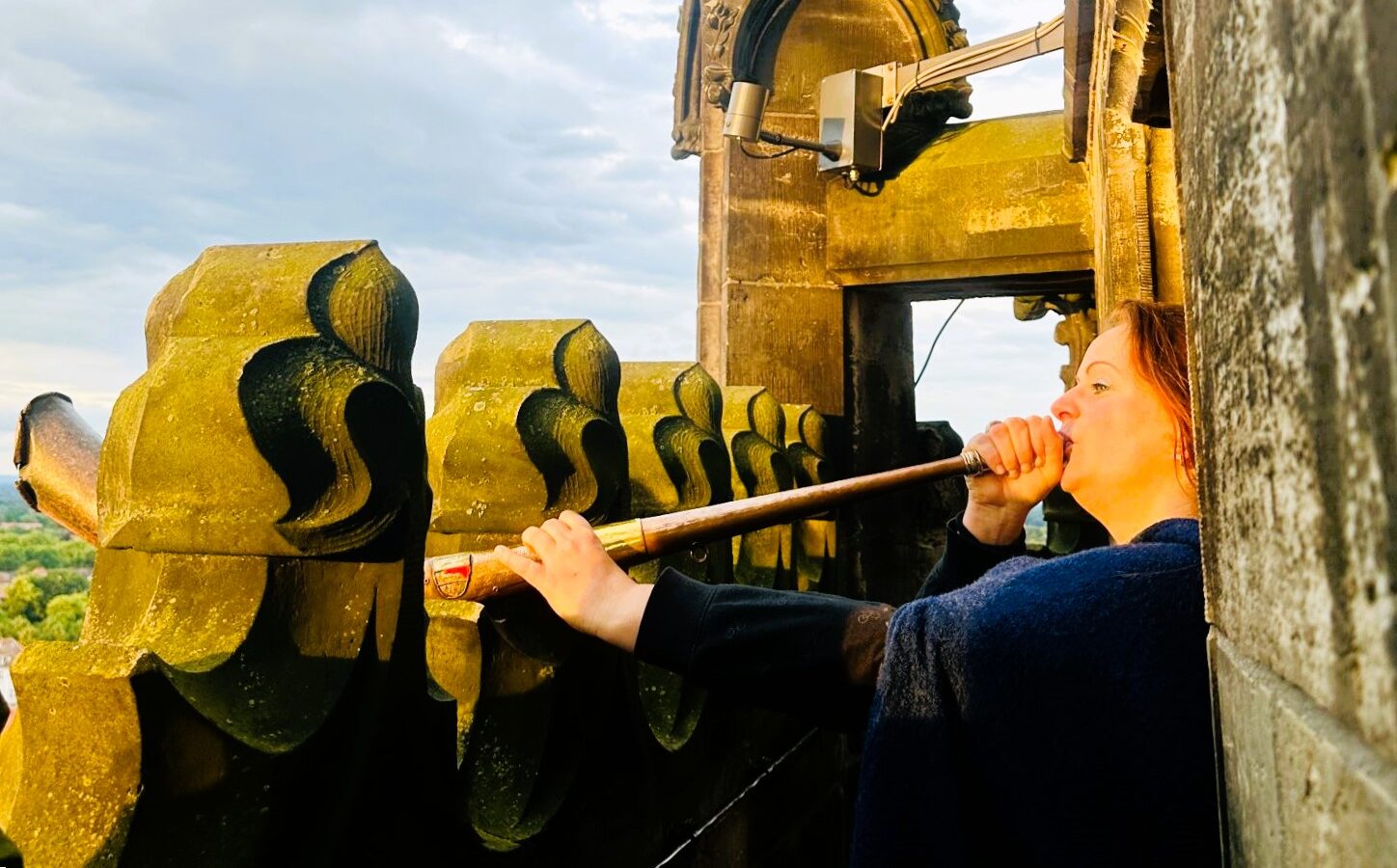 Martje Thalmann, the first female “tower keeper” has watched over Münster, Germany, from St. Münster since the 1300s, blows an antique horn into the night sky. @Barbara Redding. 