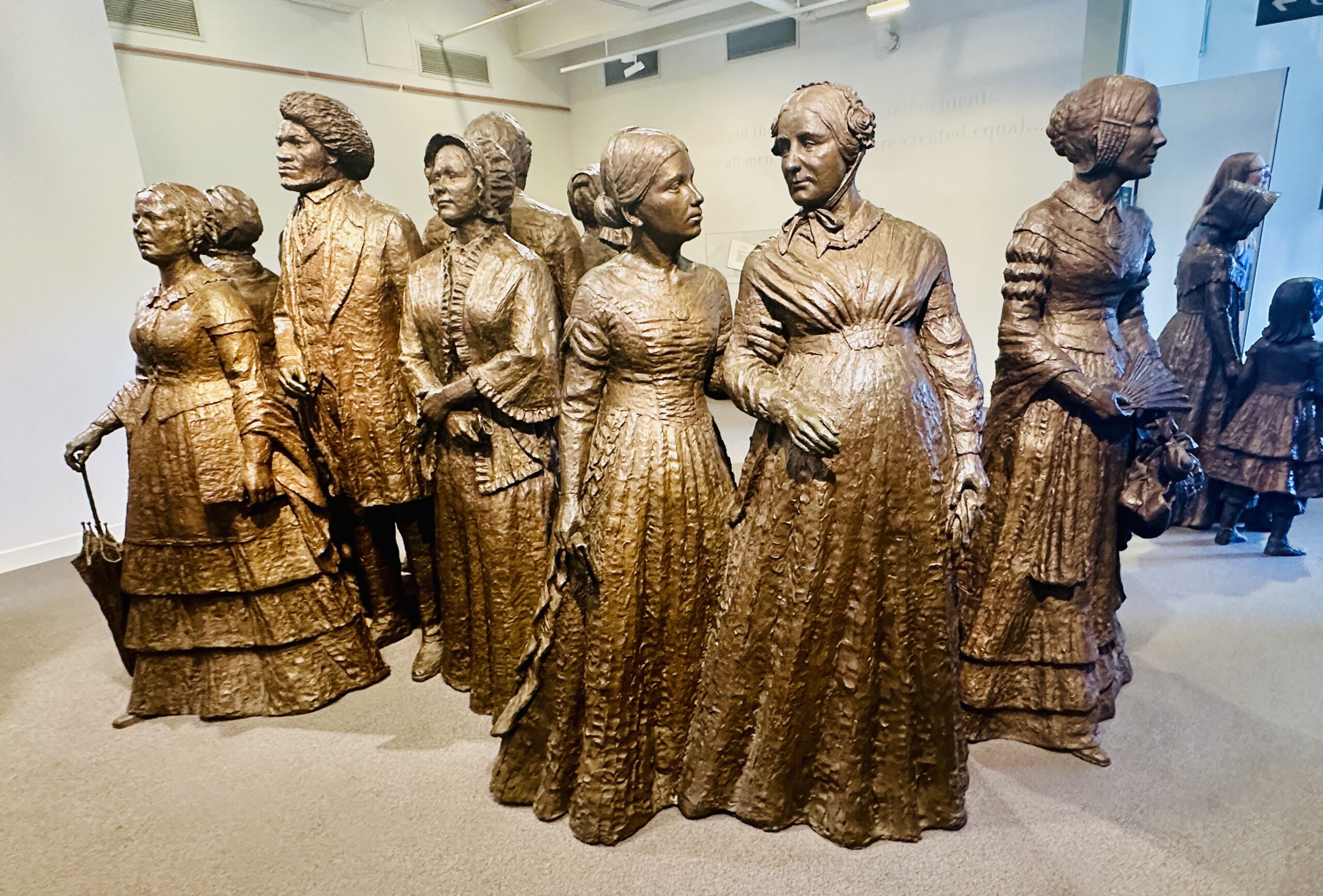 Life-size bronze statues of the “First Wave” of activists stand like sentinels in the foyer of the Visitors Center of the Women's Rights Park.