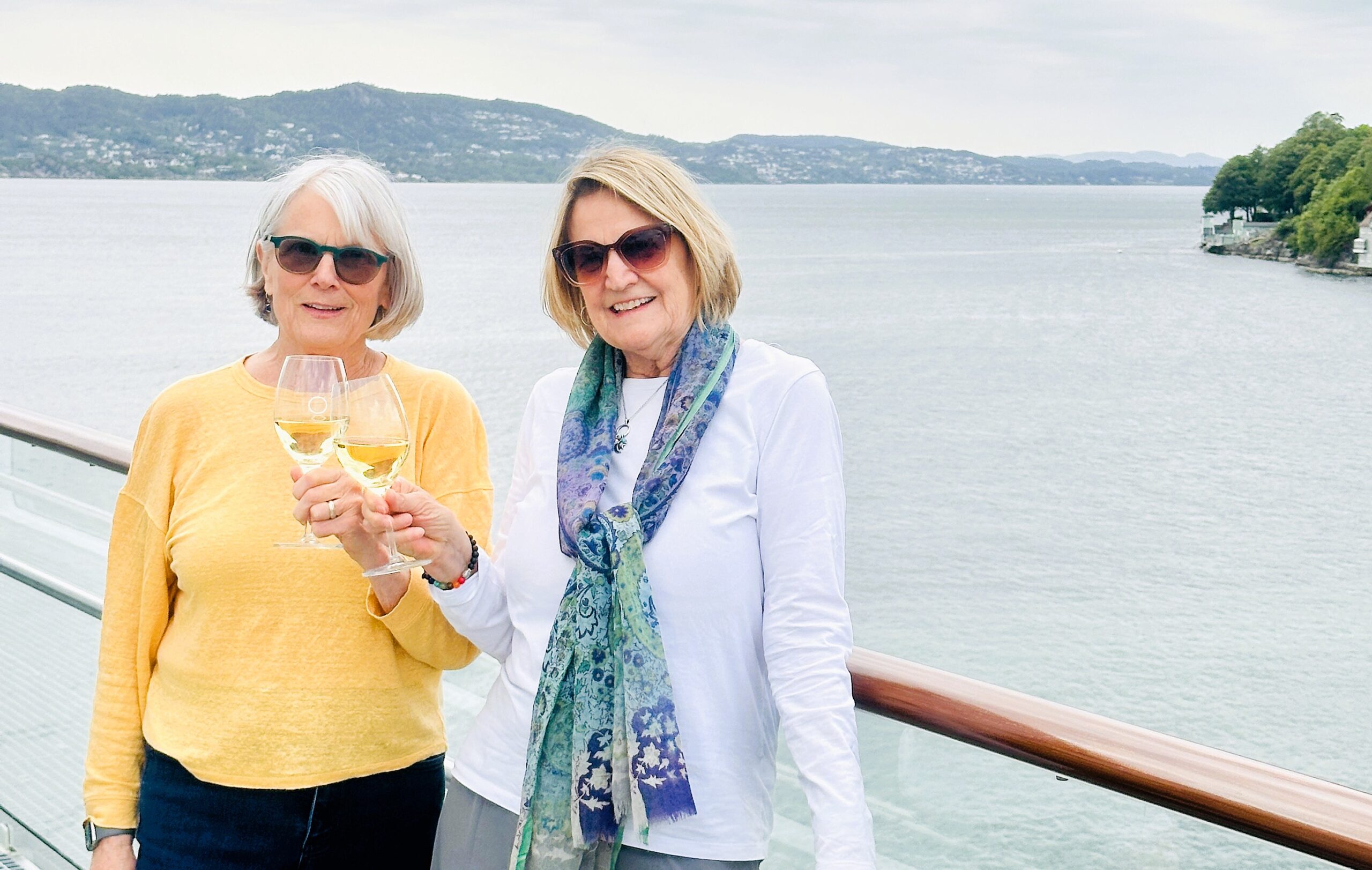 My sister Linda and I clink our wine glasses aboord our Havila Voyages cruise ship.